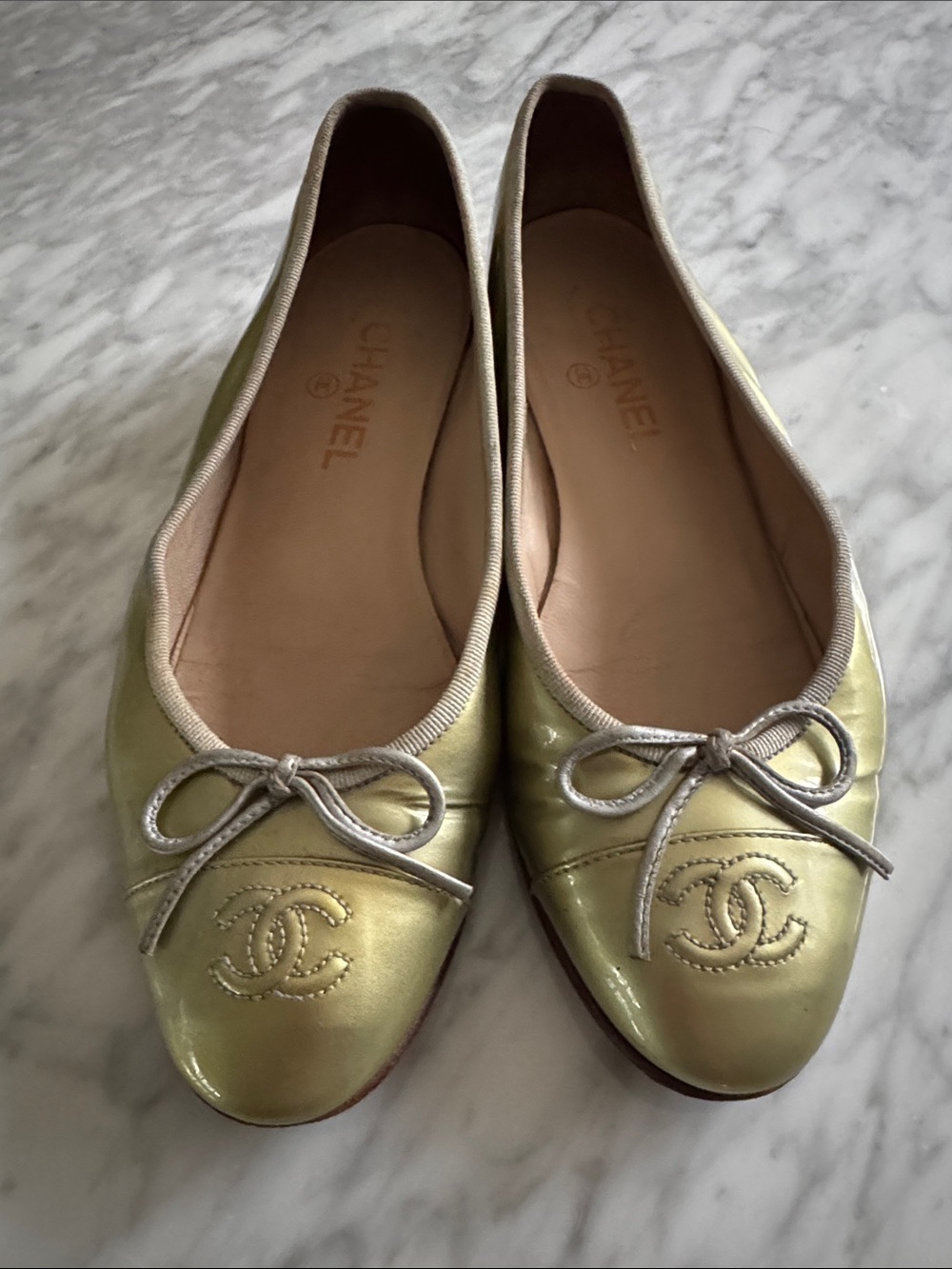 Chanel shiny gold patent leather ballet style stitched logo bow round toe flats.